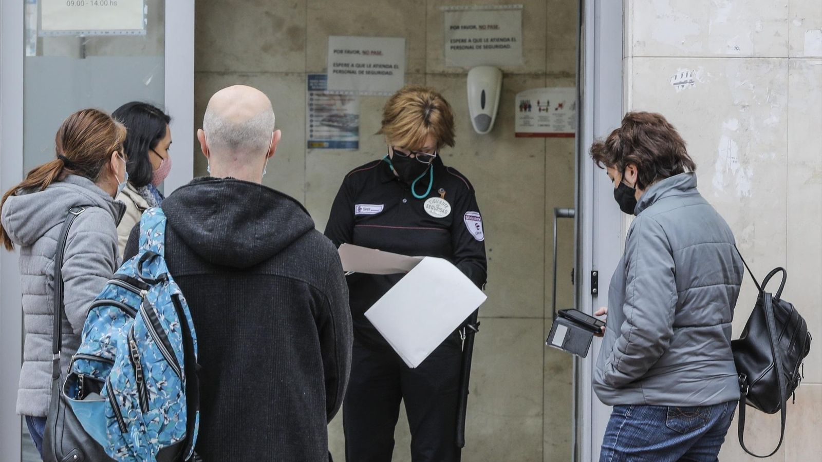 Diverses persones fan cua davant d'una oficina de Labora