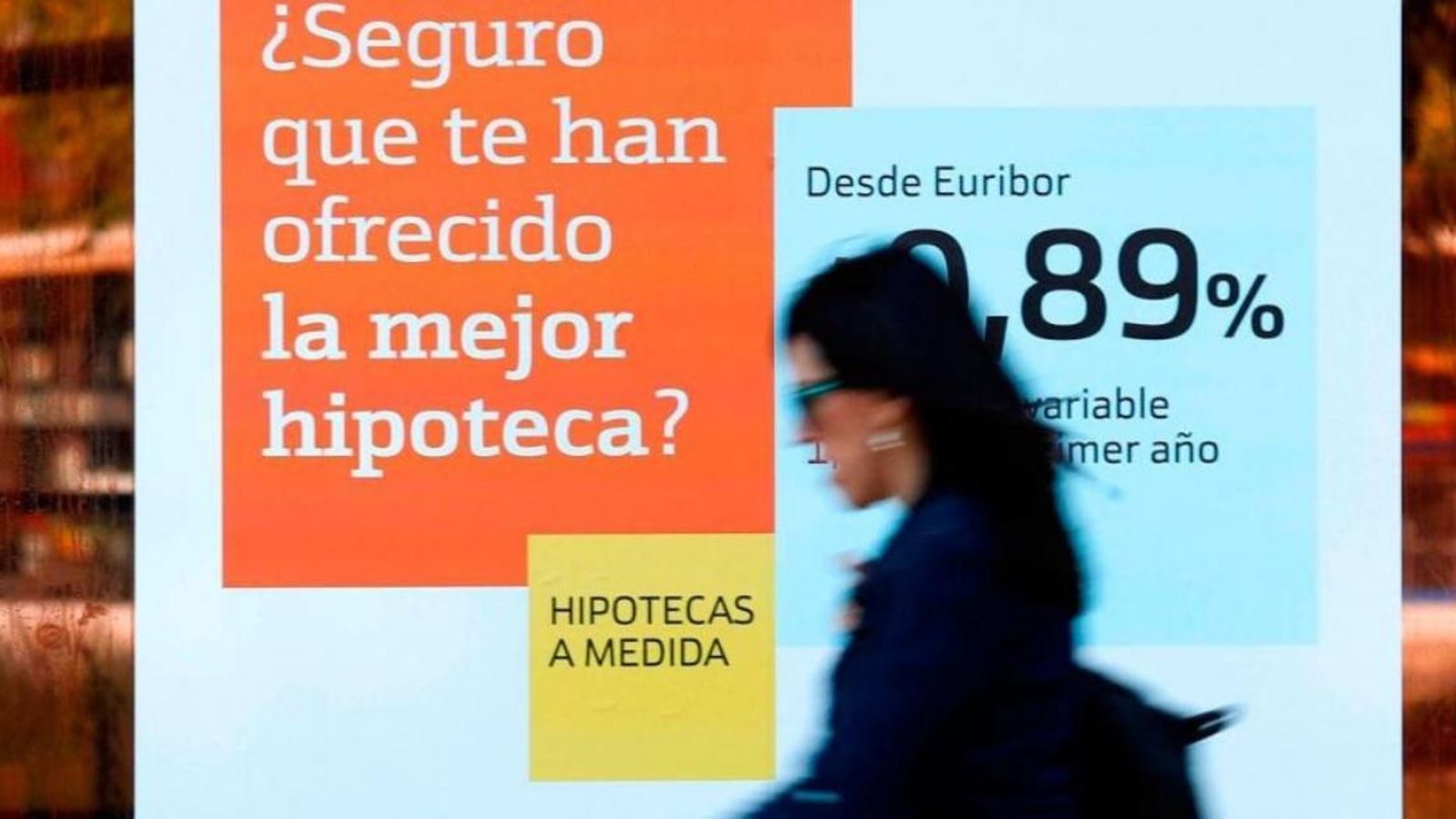Imatge d'arxiu d'una dona passant davant d'una entitat bancària