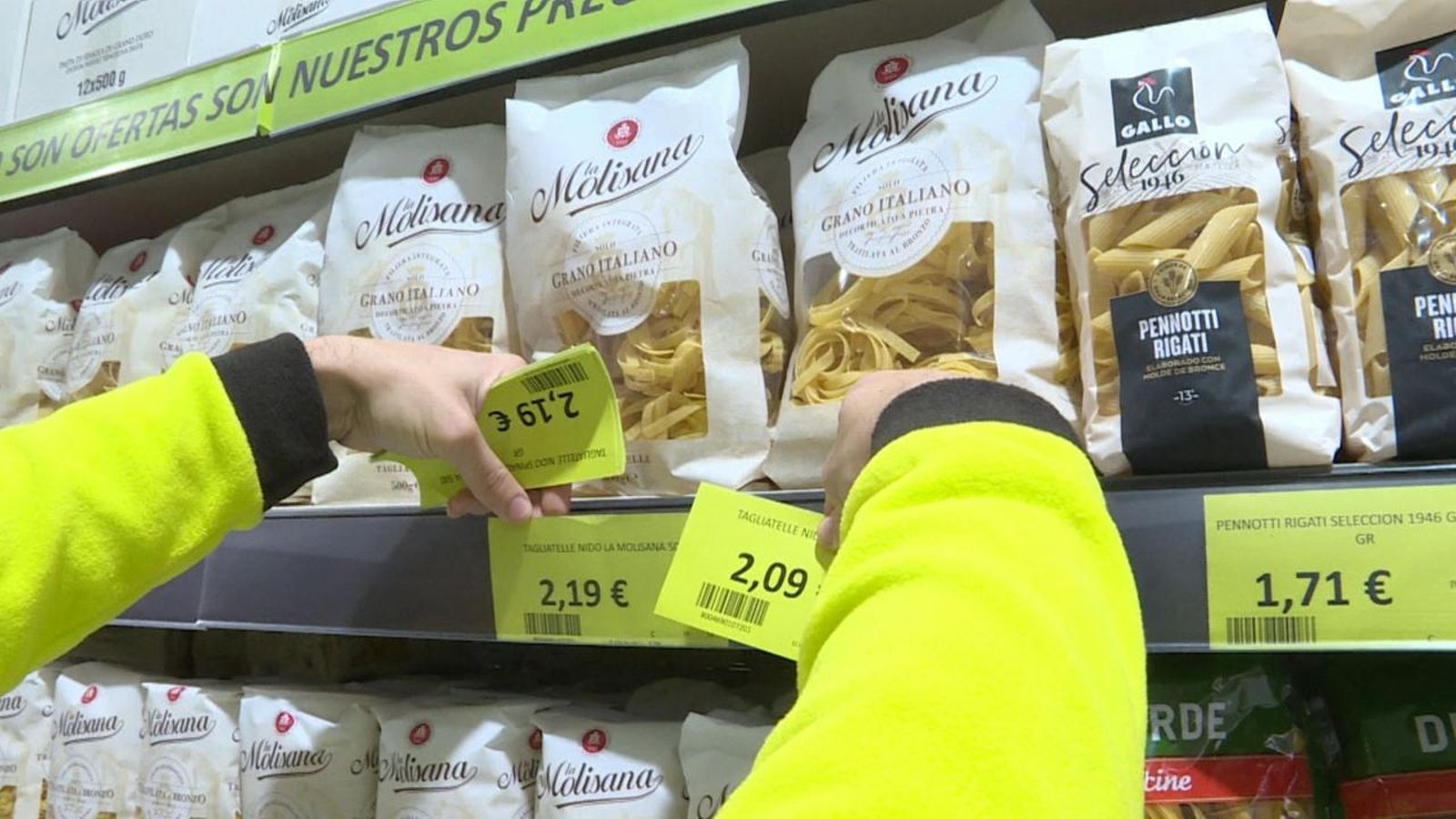 Un treballador canvia els preus dels productes d'un supermercat
