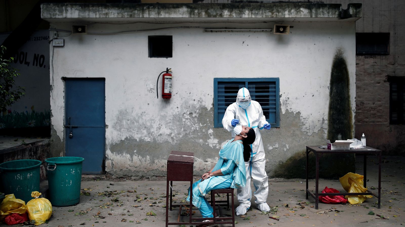 Un treballador pren una mostra d'una persona en una escola, enmig de la propagació de la pandèmia a Nova Delhi, l'Índia