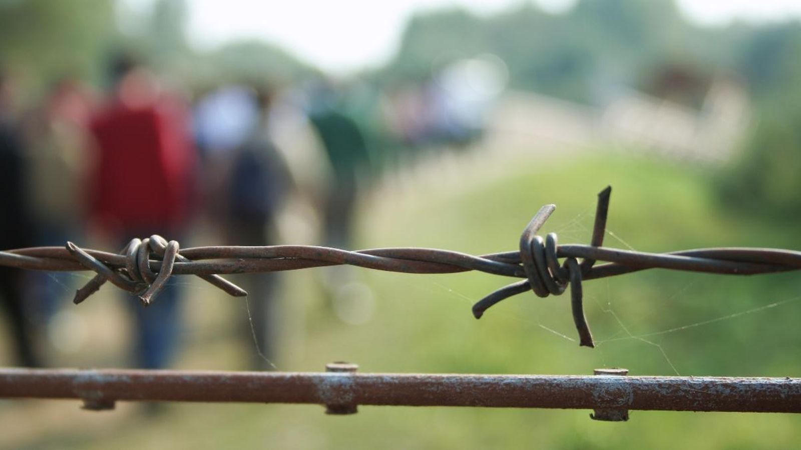 Persones refugiades arribant a una frontera
