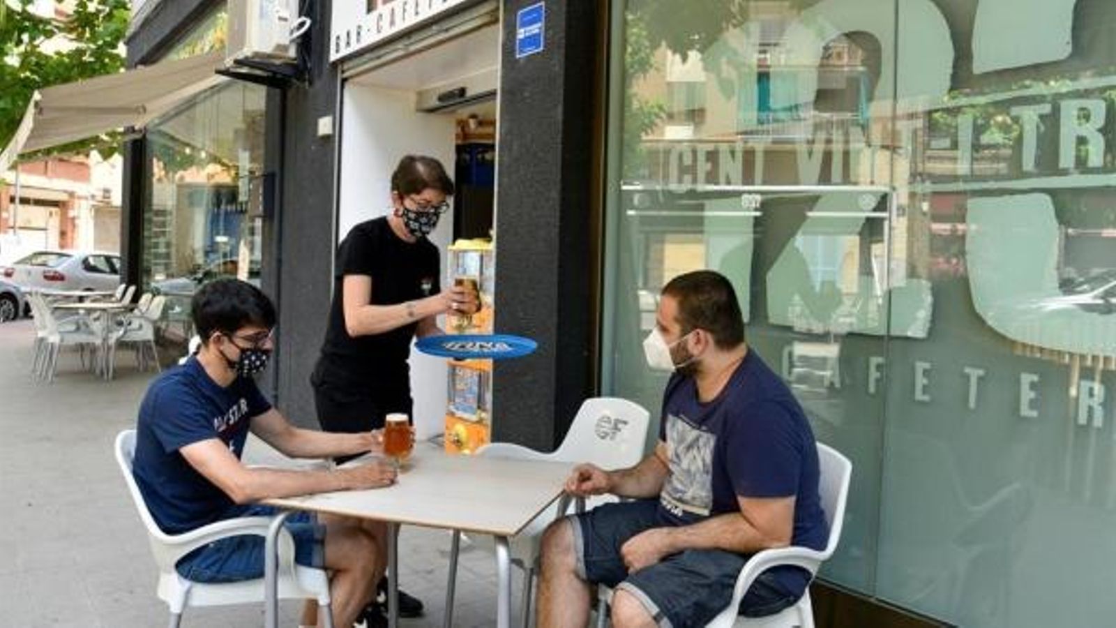 Dos joves amb mascareta, en la terrassa d'un bar a Lleida