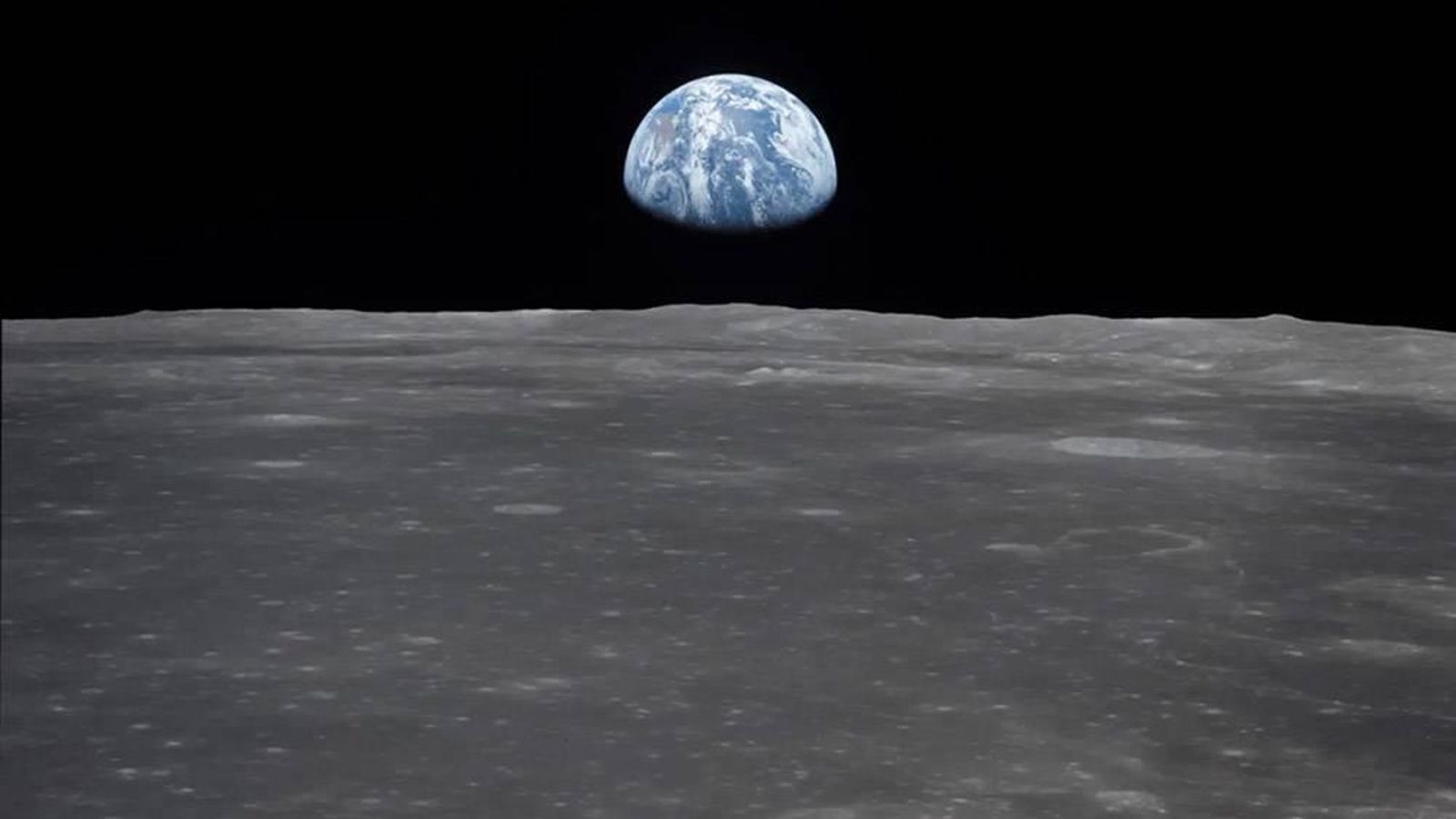 Aquesta vista de la nau espacial Apol·lo 11 mostra la Terra elevant-se sobre l'horitzó llunar