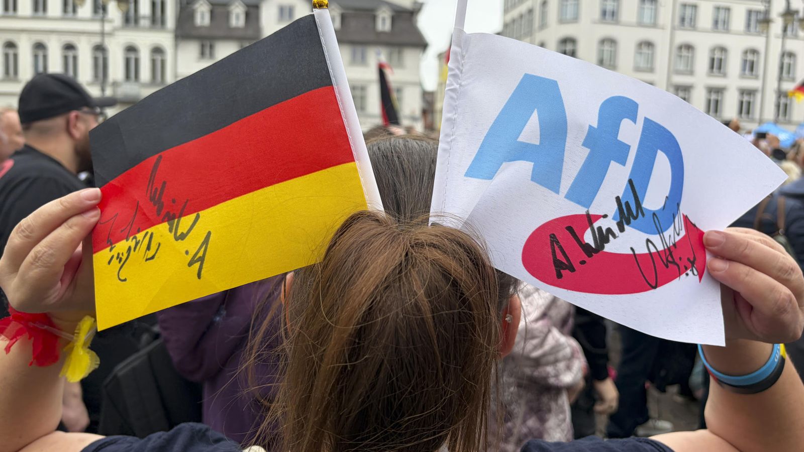 Una dona mostra les signatures d’Alice Weidel, copresidenta d’Alternativa per a Alemanya (AfD), i d’Ulrich Siegmund durant el míting de final de campanya de la formació d’ultradreta, este dissabte a Schwerin.