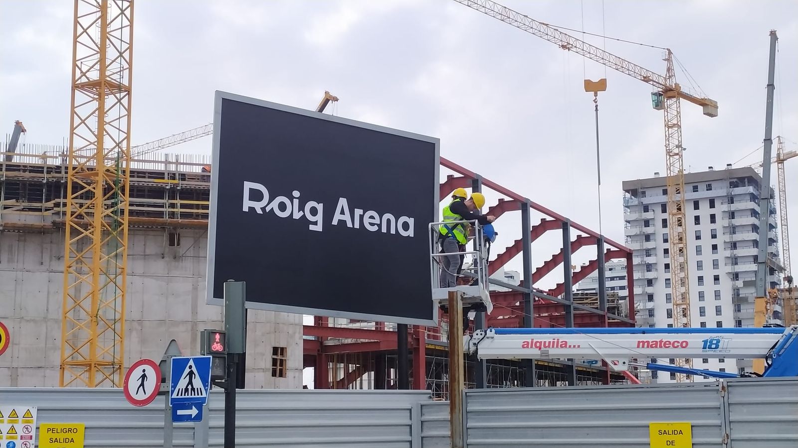 Cartell del Roig Arena en la porta de l'espai en obres