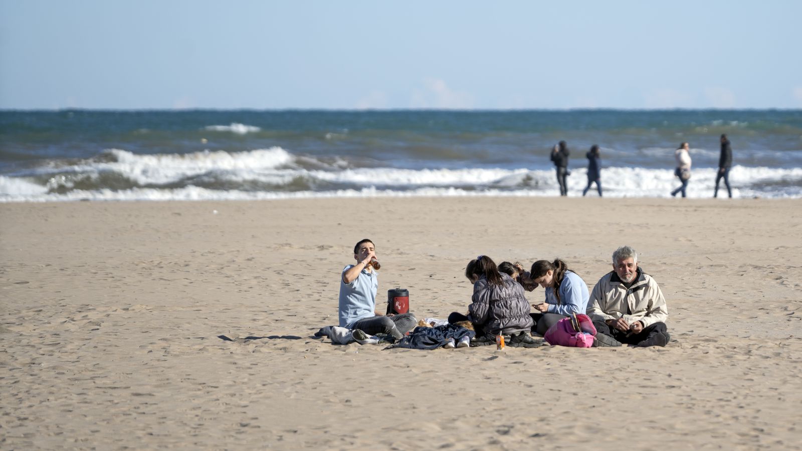 Un grup de persones gaudeix de les temperatures càlides a la platja de la Malva-rosa de València