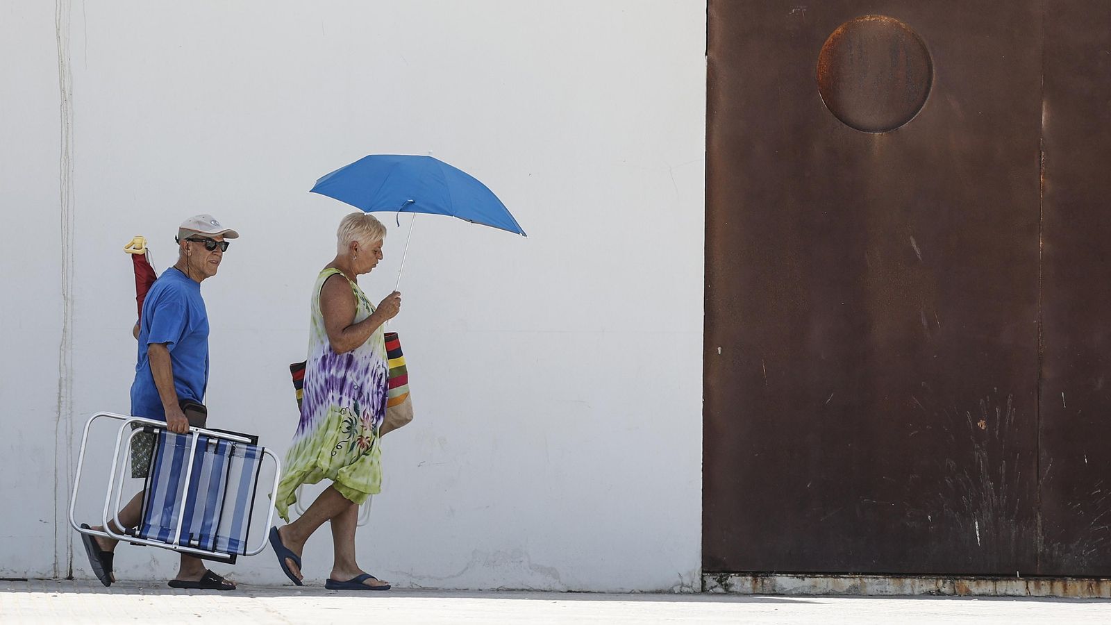 Dues persones van cap a la platja en una imatge d'arxiu d'aquest estiu