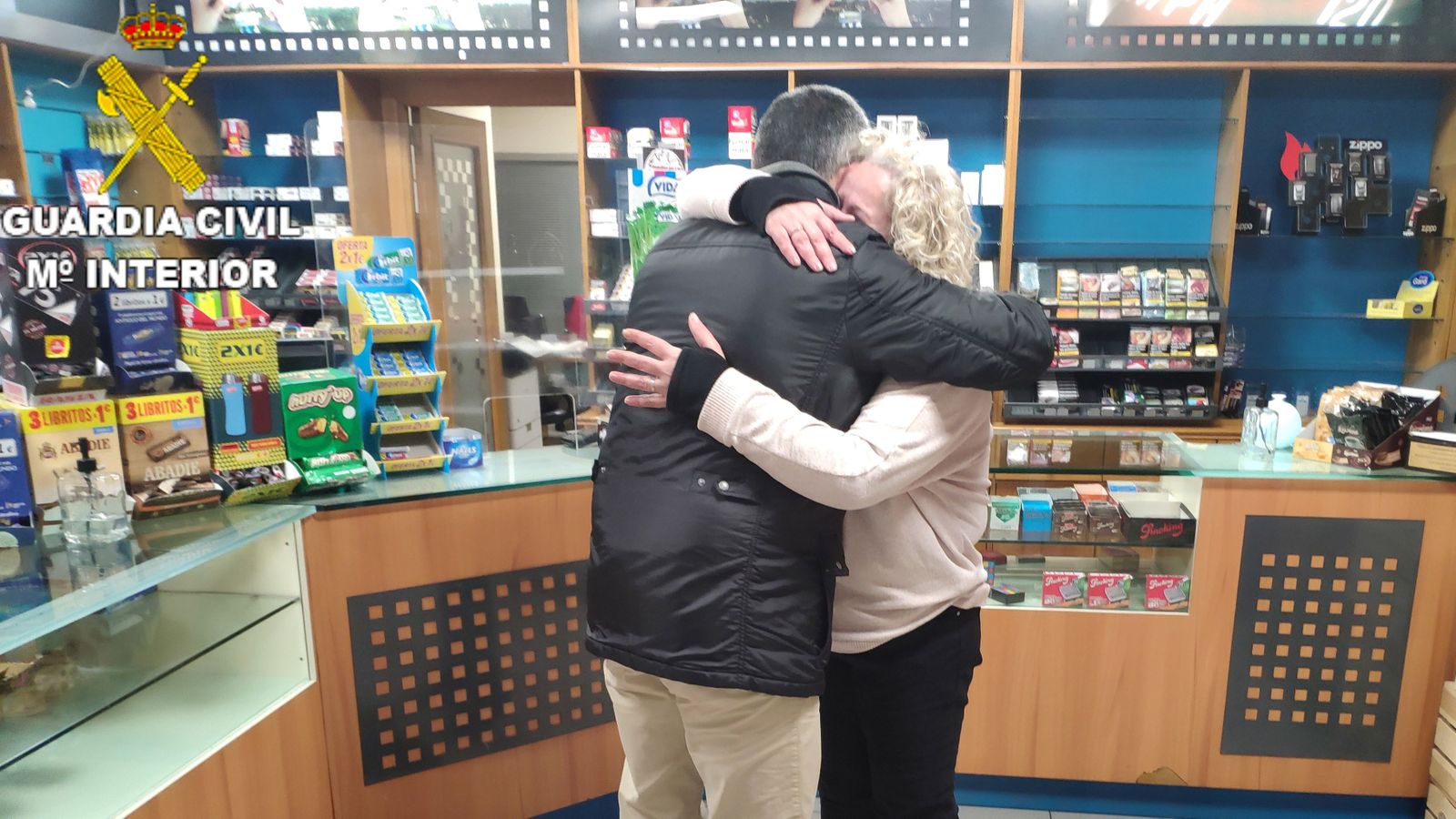 Abraçada entre l'agent i la propietària de l'estanc, a Gandia