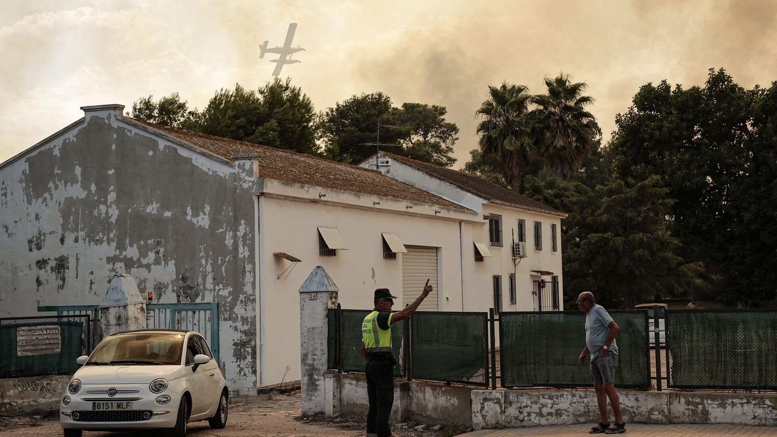Un agent de la Guàrdia Civil dona indicacions a un veí durant l'evacuació del Saler