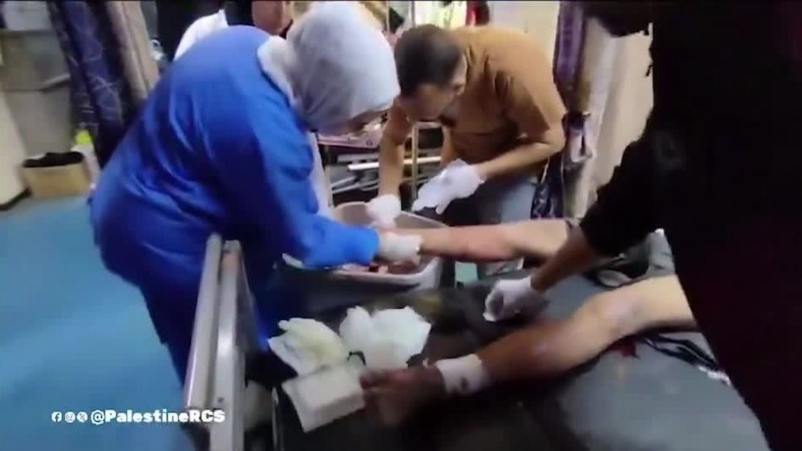 Un grup de sanitaris atén un ferit a l'hospital Al-Amal, alié als dispars que s'escolten a l'exterior