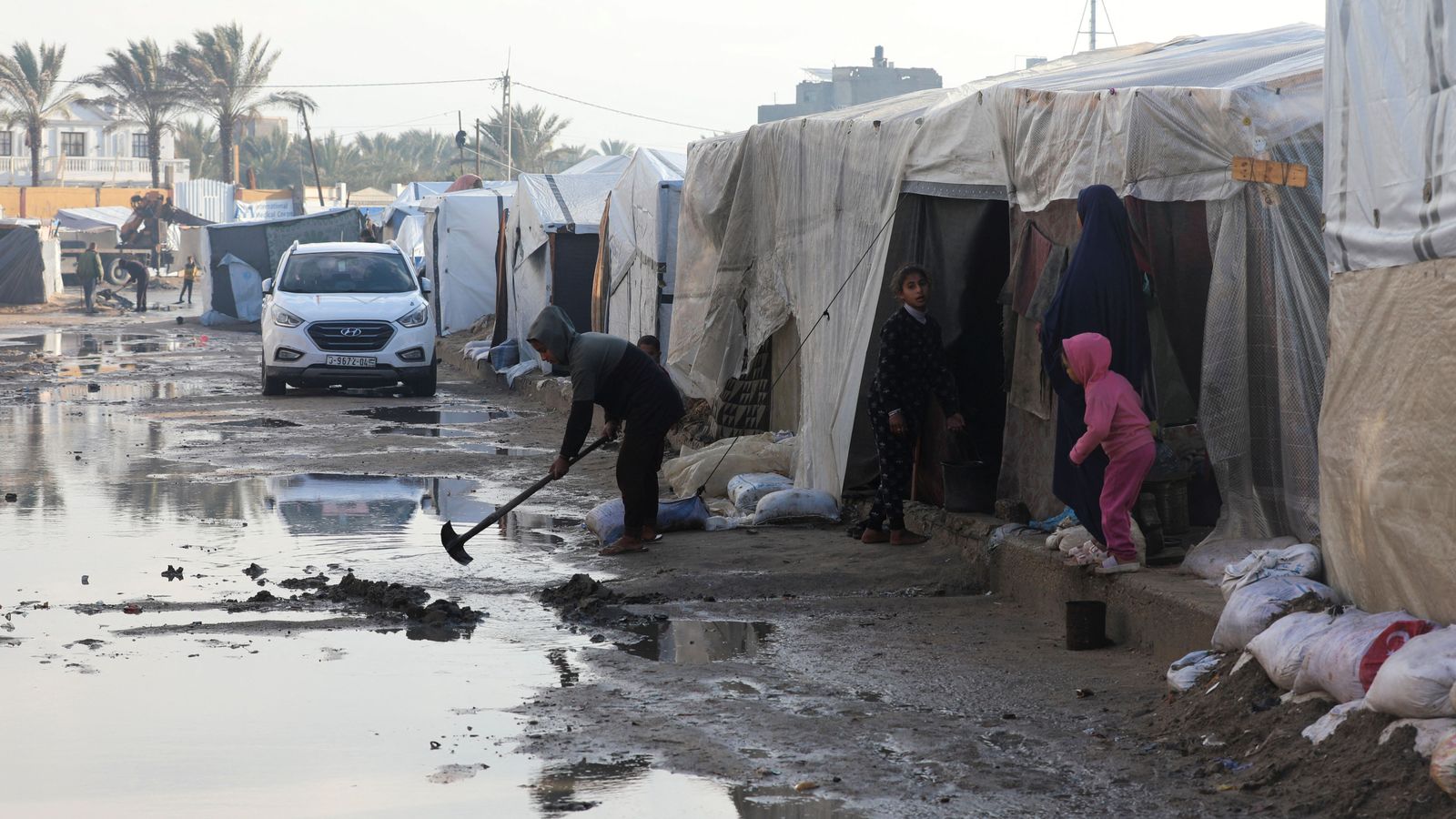 Una família palestina trau fang després de les inundacions causades per les pluges a Deir Al-Balah, en el centre de Gaza