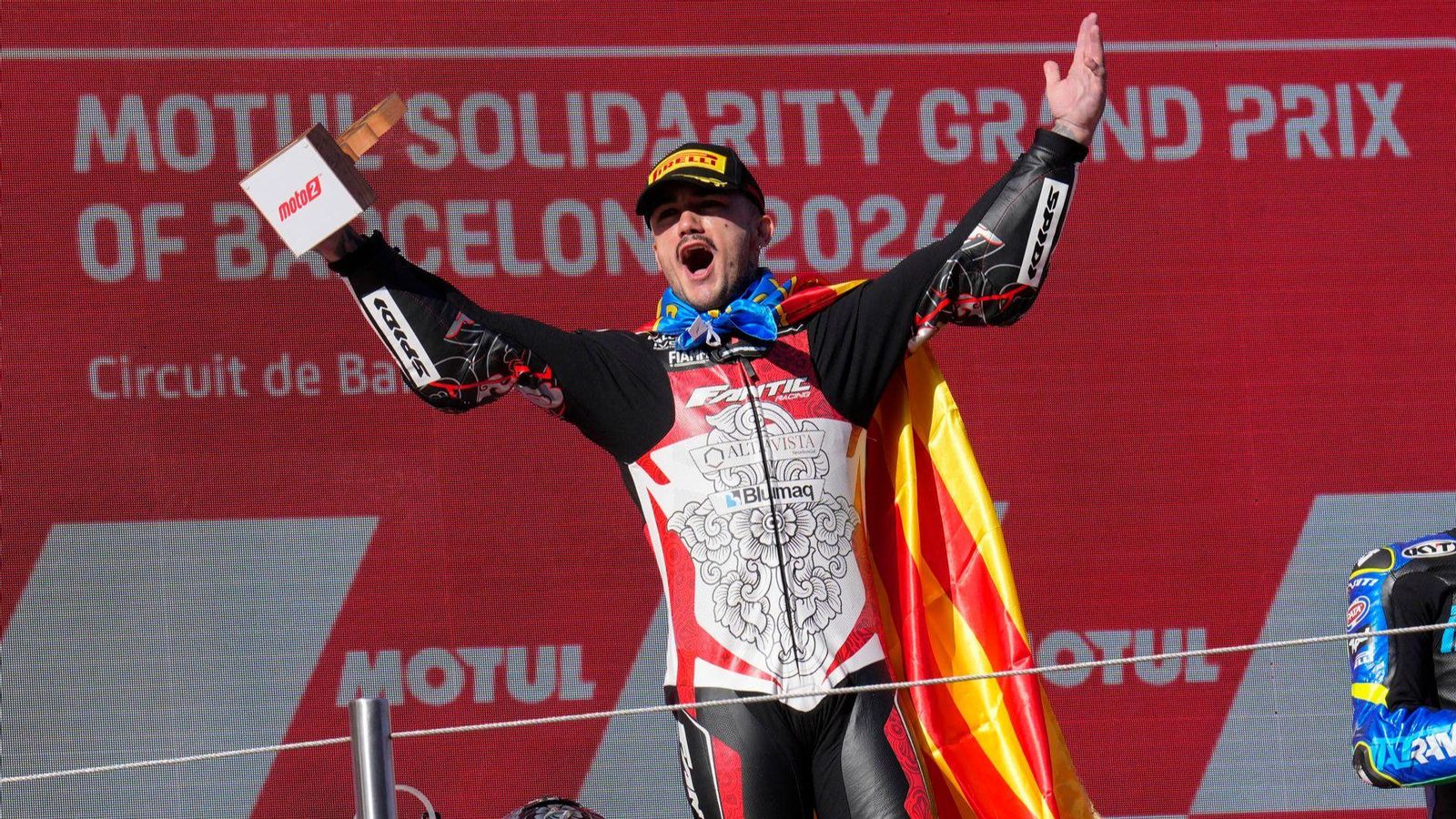 Aron Canet celebra el triomf en el pòdium amb la senyera