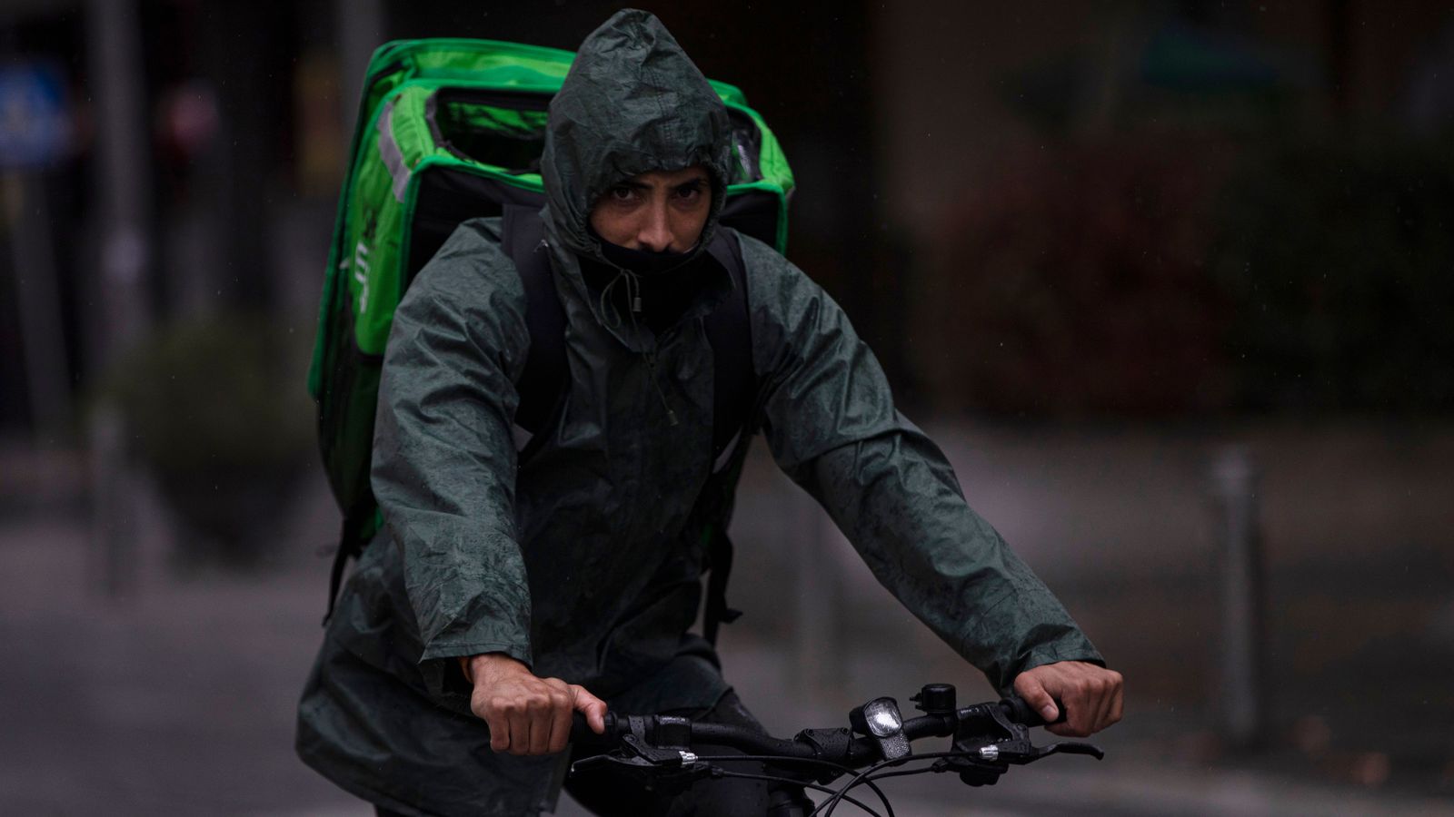 Imatge d’arxiu d’un rider que treballa sota la pluja, protegit amb un impermeable