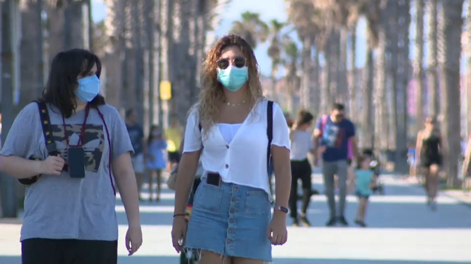 Dues dones passegen amb mascareta pel passeig de la platja de la Malva-rosa, a València