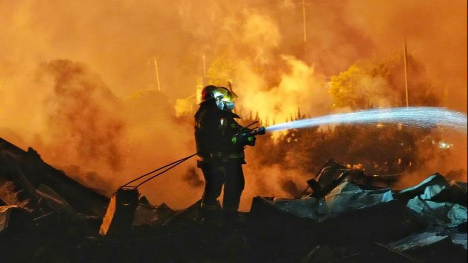 Un bomber treballa entre enderrocs després de l’explosió en una fàbrica de focs artificials a Liuyang, Hunan (Xina)