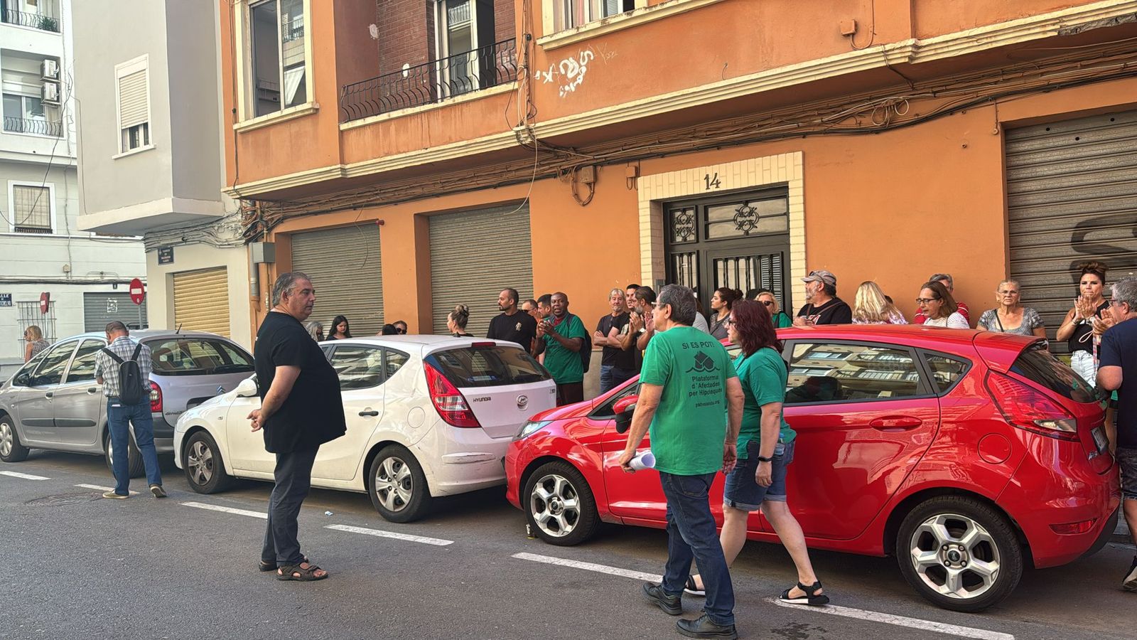 Un grup de membres de la PAH i altres persones a les portes de la vivenda