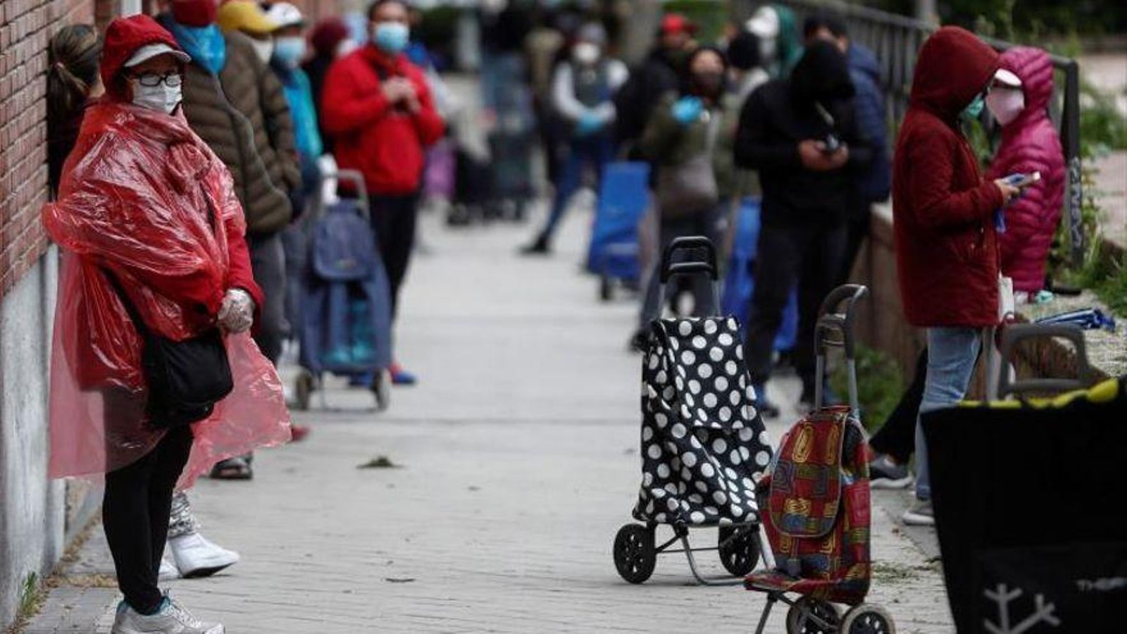 Cua de persones per a recollir aliments davant la seu de la Fundació Madrina, a la parròquia Santa María Micaela de Madrid