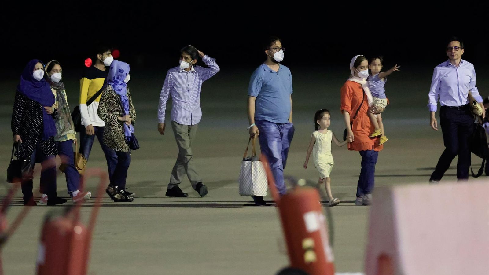 Diversos refugiats baixen de l'avió després d'aterrar a Torrejón de Ardoz