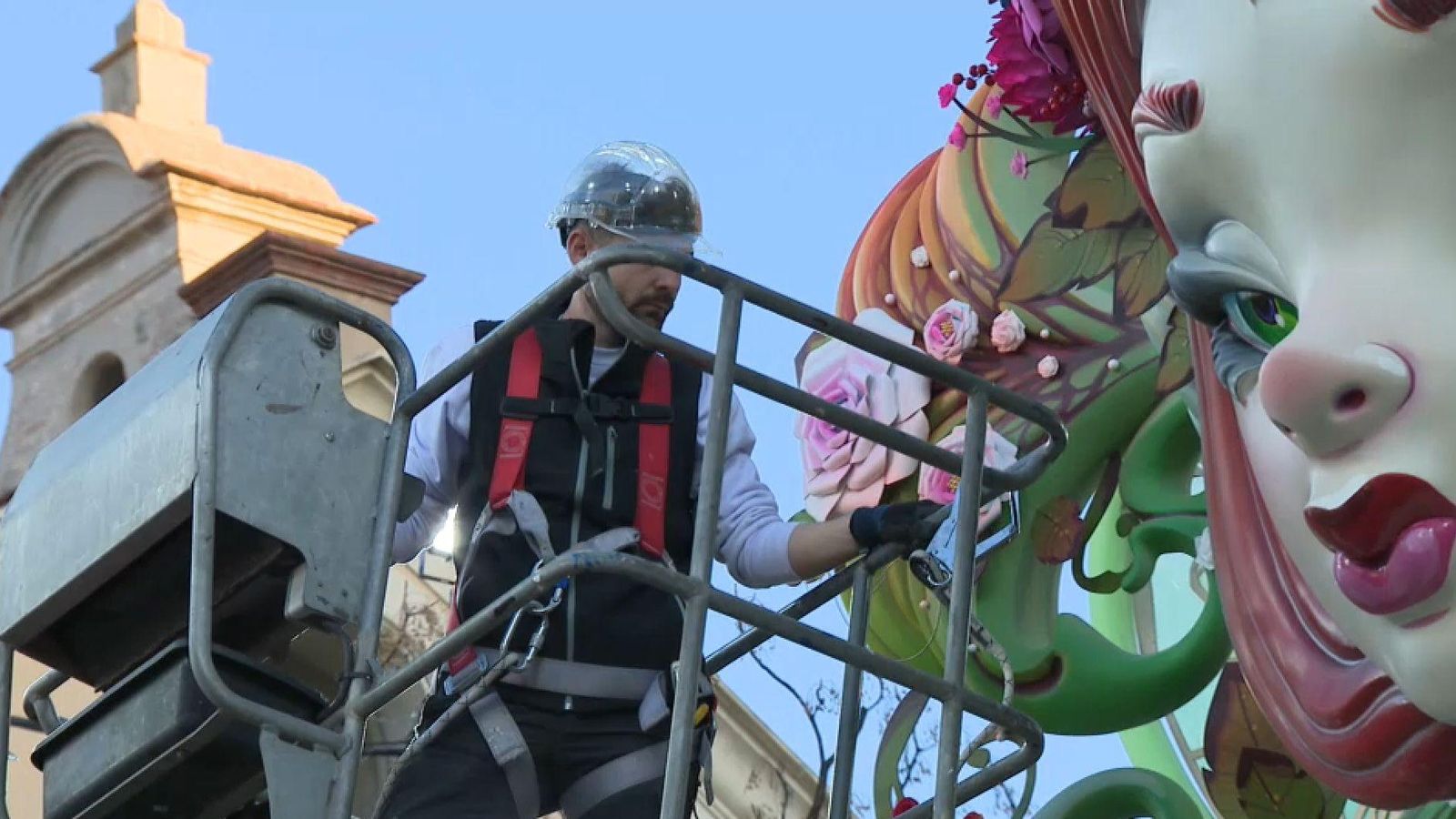 Un treballador d'un taller d'artistes de València, provist d'arnés i casc, supervisava aqeust dilluns el remat d'un monument faller