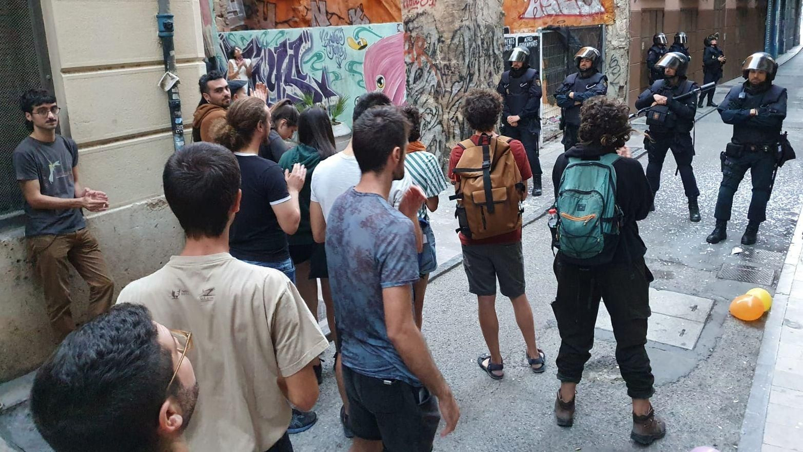 Algunes de les persones que s'han concentrat per a mostrar suport a la parella desnonada front a una barrera d'agents de policia desplaçada al carrer Caixers