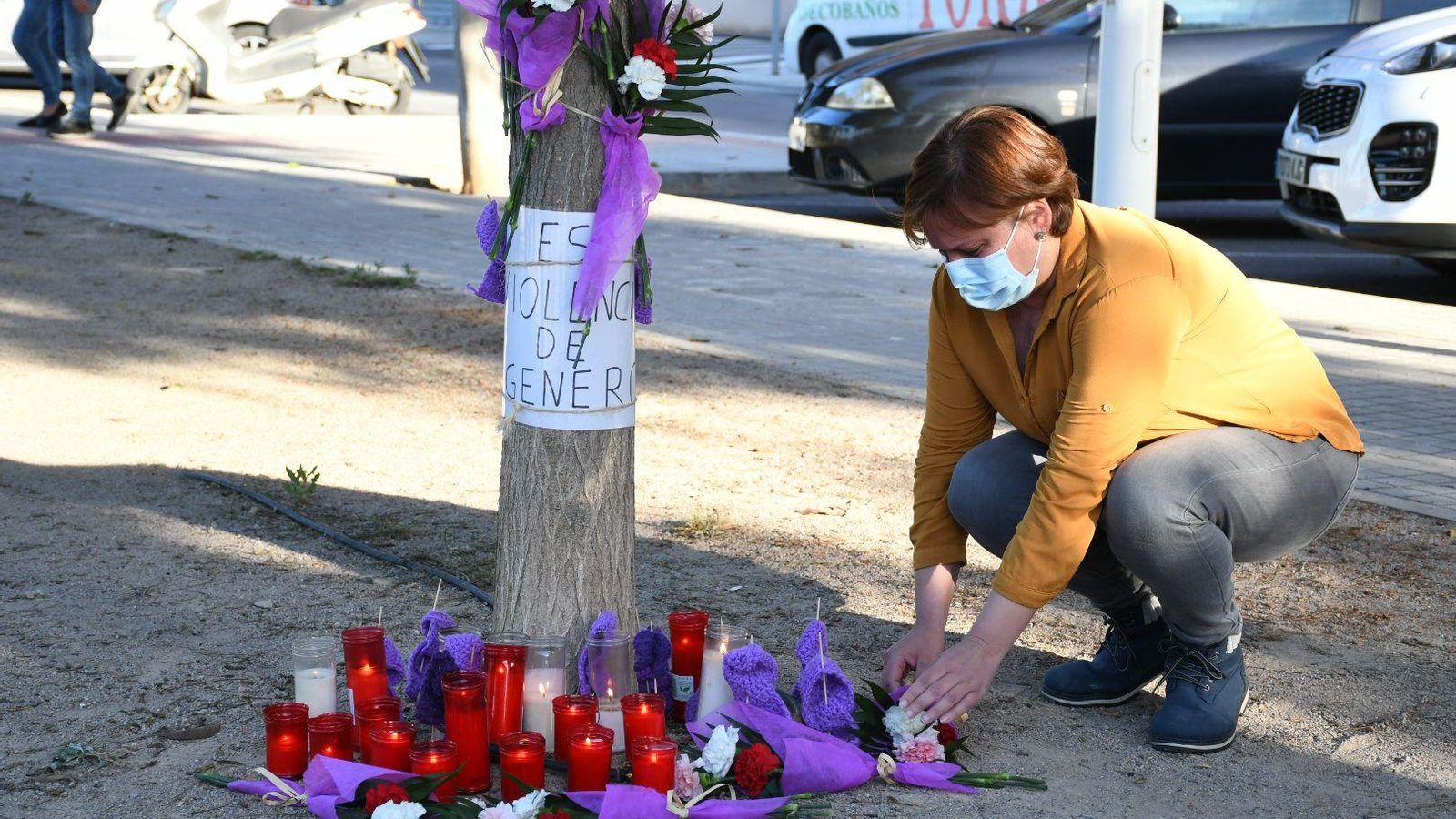 Una veïna deixa flors en un altar improvisat durant el recorregut