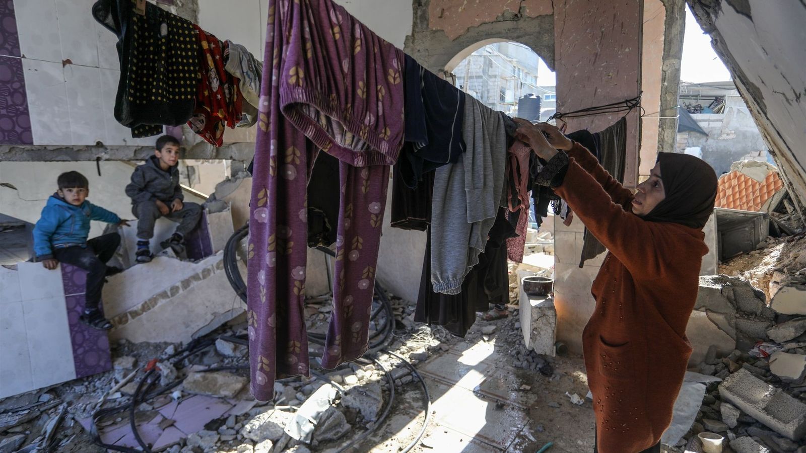 Una família es refuine en les ruïnes d'un edifici després dels bombardejos d'Israel a Rafah