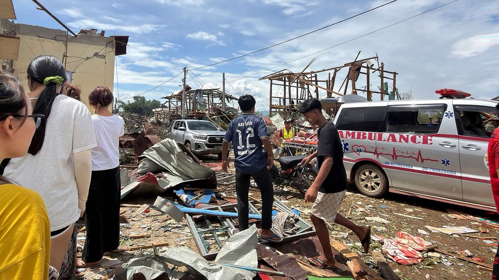 Veïns caminen prop d’un edifici danyat després de l’explosió registrada en un dipòsit d’explosius a Kaung Tat, a l’estat septentrional de Shan, a Birmània
