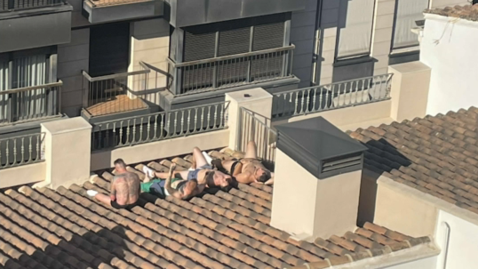 En la imatge, un grup de turistes prenent el sol a la teulada del seu apartament turístic