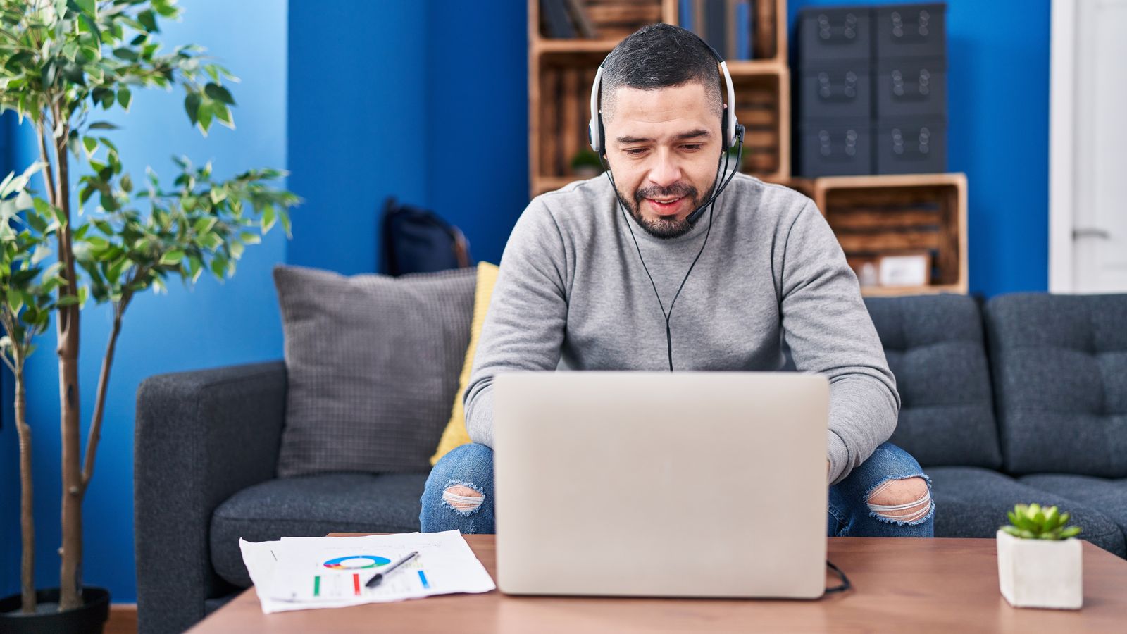 Un home teletreballant a casa amb l'ordinador