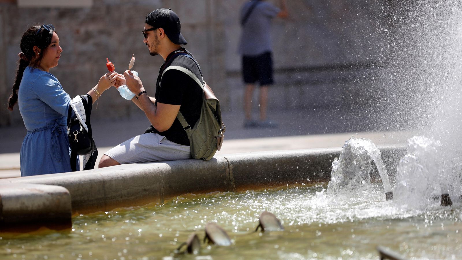 Una parella menja gelats junt a la font de la Plaça de la Mare de Déu de València el passat cap de setmana