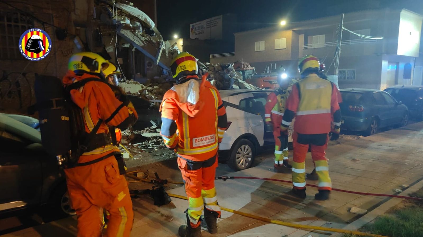 Efectius del Consorci de Bombers de València inspeccionen els enderrocs de l'edifici desplomat a Benetússer