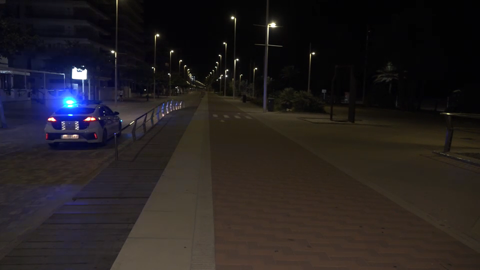 Un cotxe de policia patrulla pel passeig marítim de Gandia durant aquesta matinada