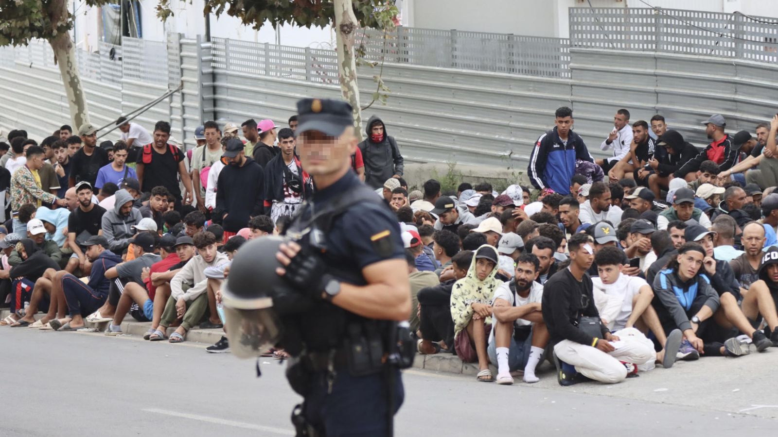 Un agent de la Policia Nacional supervisa una zona amb una multitud de persones concentrada a Ceuta, este dimarts