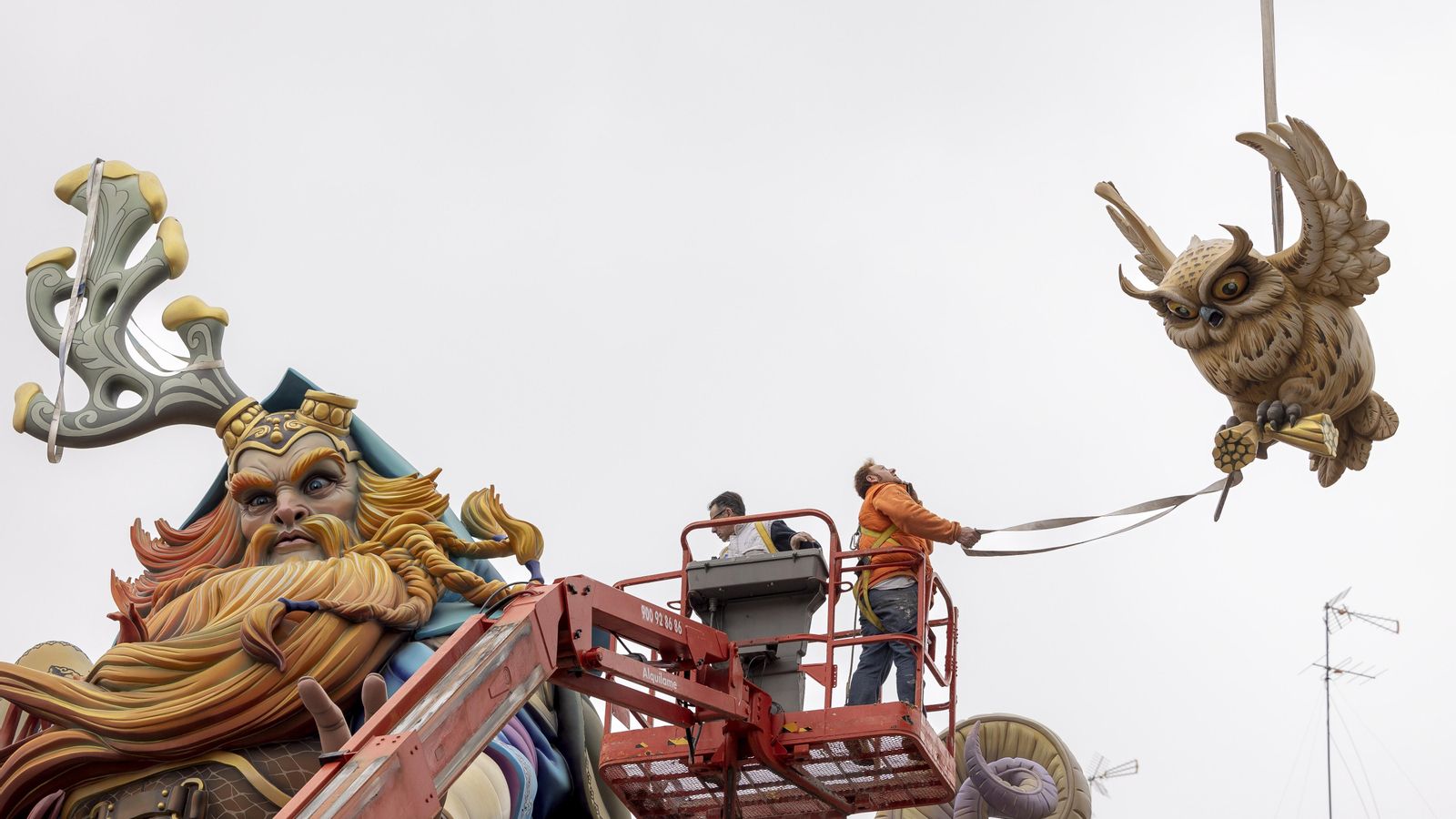 Un equip d’artistes fallers col·loca un dels ninots en el remat d’un monument de València, on aquest dimecres es coneixerà la falla gran guanyadora
