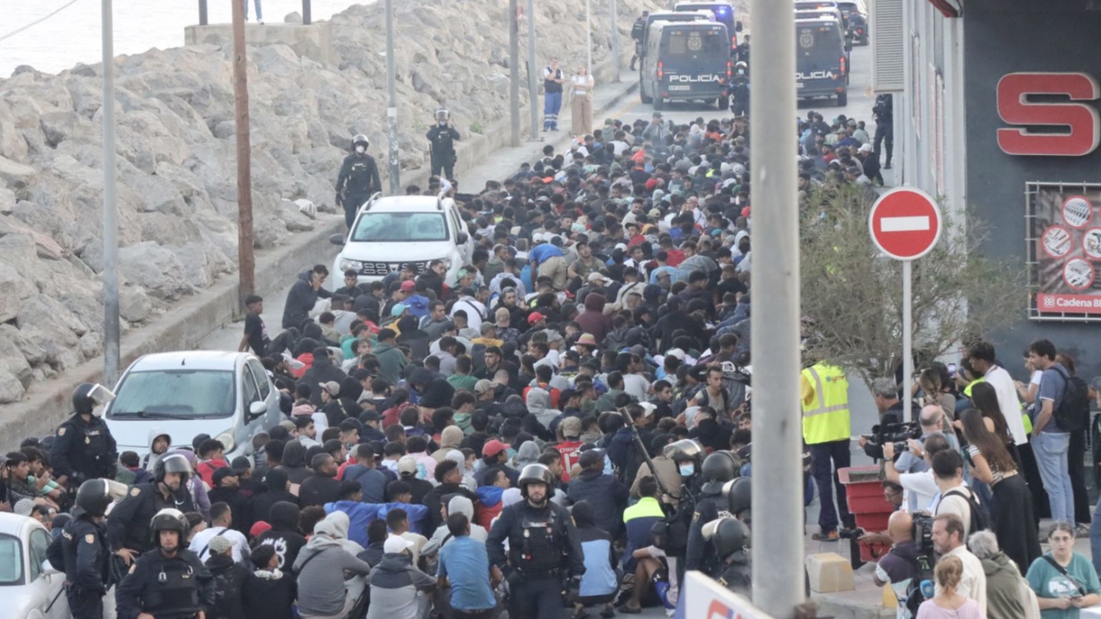 Centenars de persones migrants esperen a ser traslladat al campament del port de Ceuta
