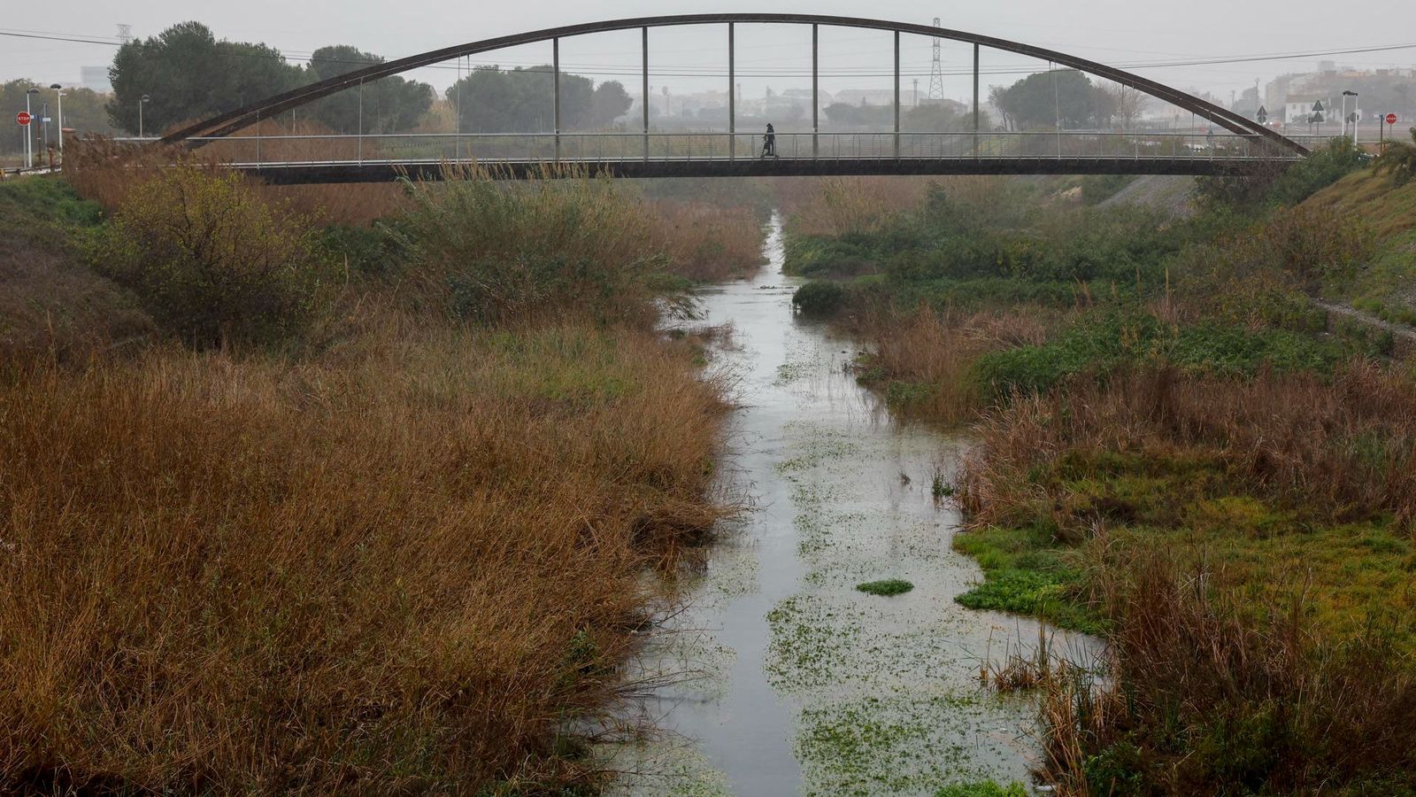 Un vianant travessa el pont sobre el Carraixent, un dels llits que ha vist incrementat el cabal, però no ha ocasionat problemes