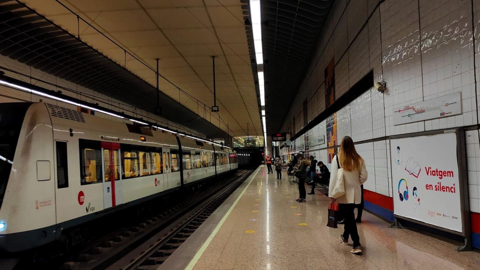 Cartell de la campanya "Viatgem en silenci" en una estació de Metrovalència
