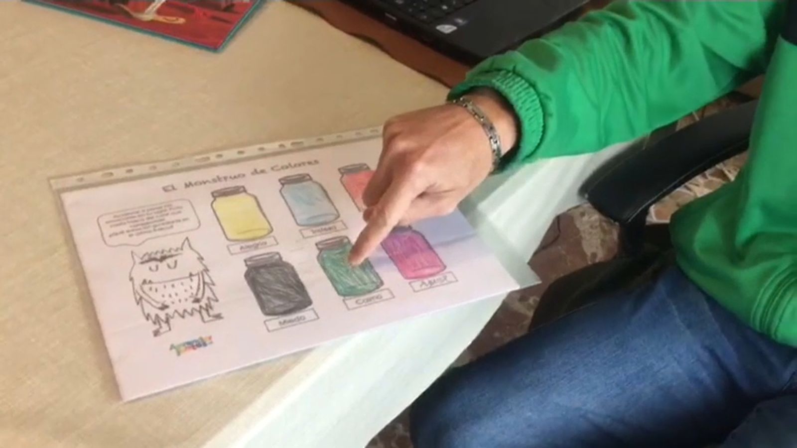 Un jove amb TEA assenyala un pictograma en una imatge d'arxiu