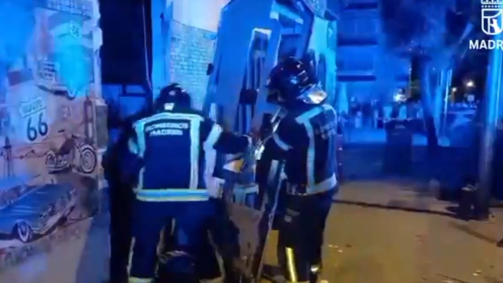 Dos bombers accedint al bar incendiat al districte de Villaverde