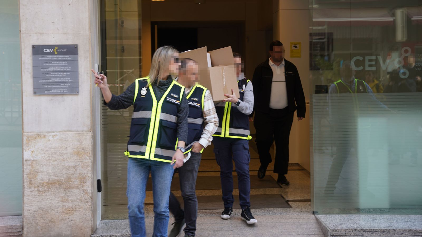 Agents de la policia nacional s'emporten caixes amb la documentació confiscada de la seu de la Confederació Empresarial Valenciana (CEV) d'Alacant
