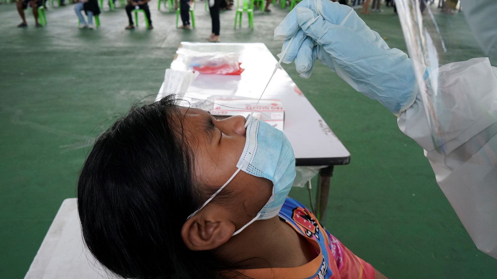 Un sanitari extrau una mostra nasal a una menor en un punt de detecció de proves del coronavirus a Bangkok