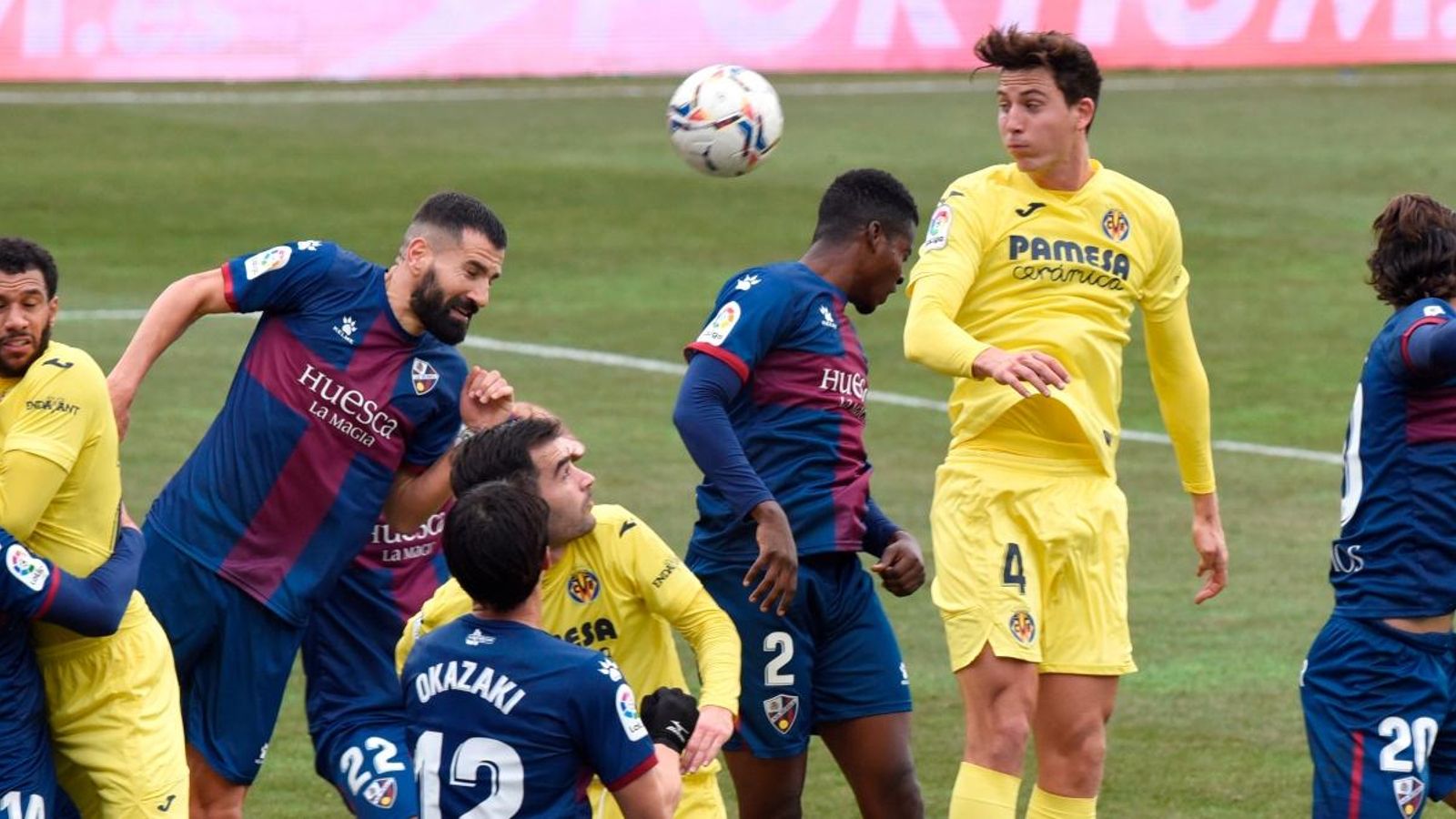 Jugadors dels dos equips disputen un baló per alt