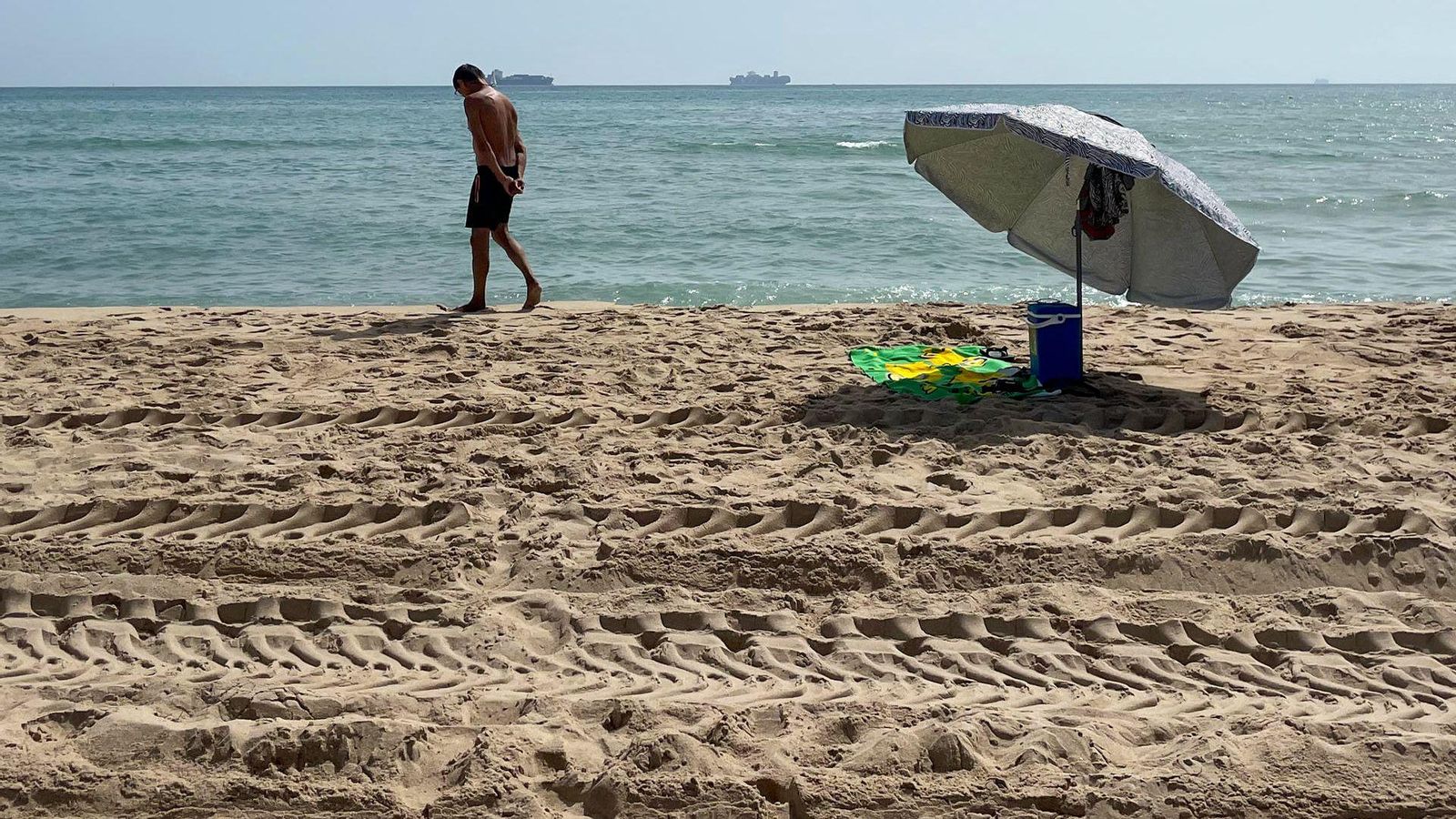 Un dels primers usuaris a tornar a les platges del sud de València observa la vora de la mar, on van arribar les restes d'hidrocarburs