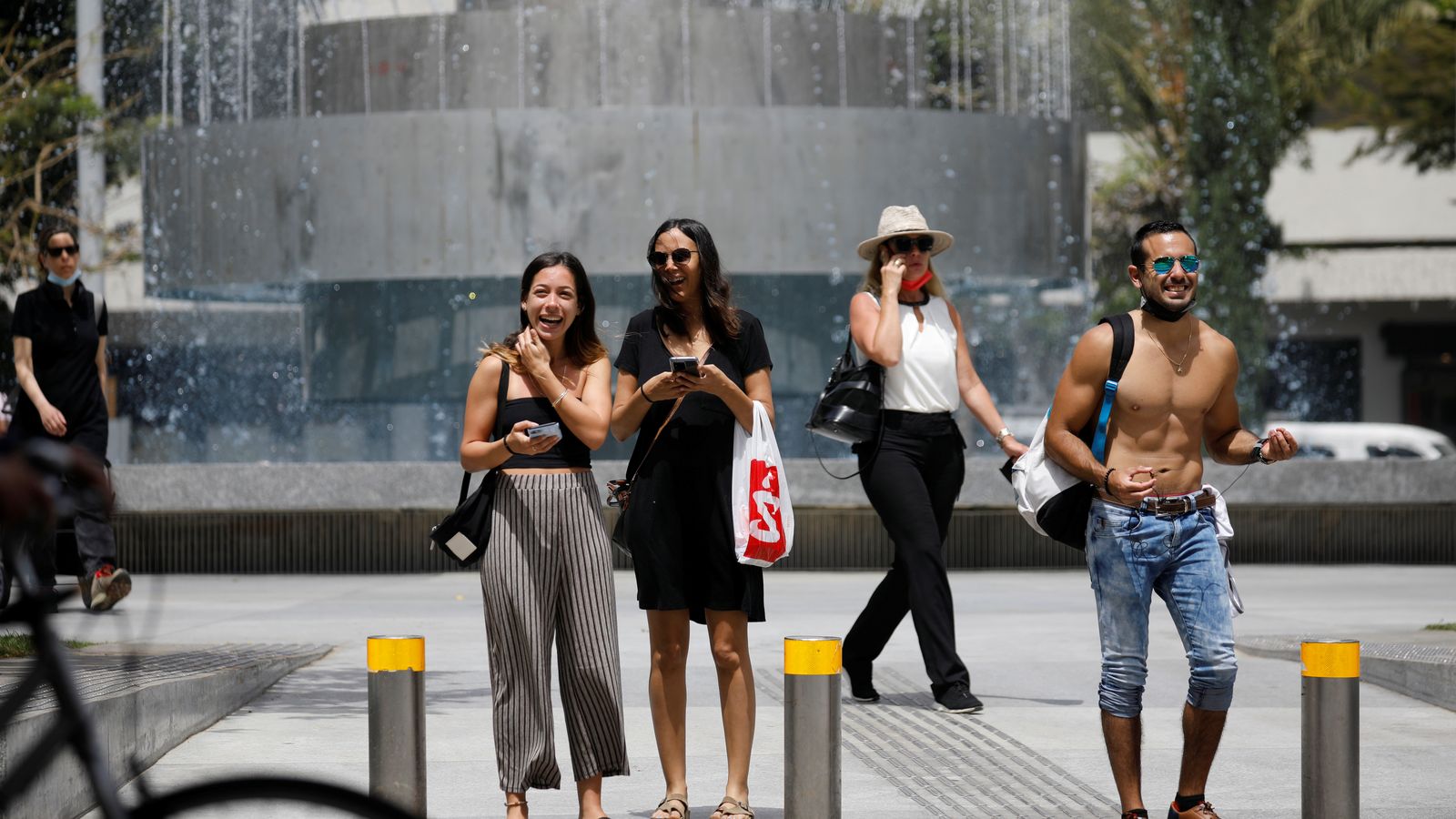Diverses persones, sense mascareta, esperen per a creuar en un pas de vianants a Tel Aviv (Israel), aquest diumenge