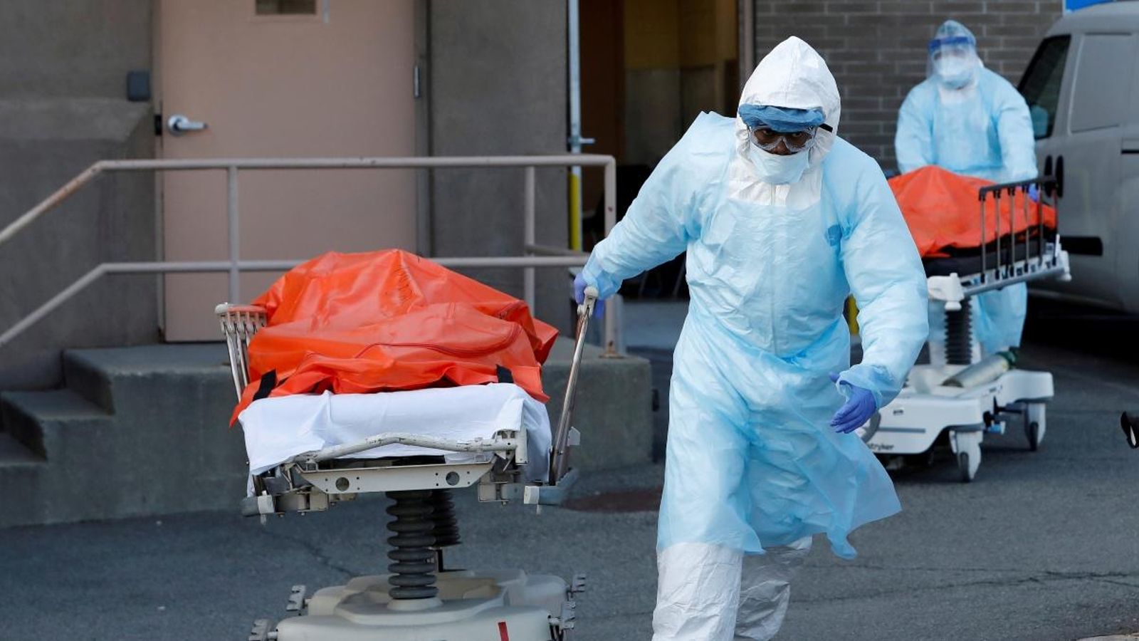 Dos sanitaris retiren els cadàvers de dos morts per coronavirus a un hospital de Nova York