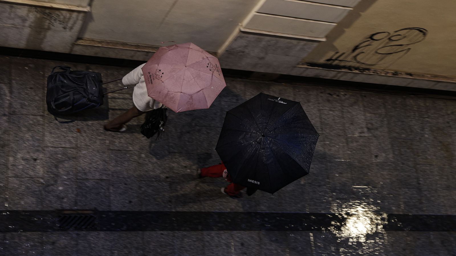 Dos persones amb paraigües en un carrer de València