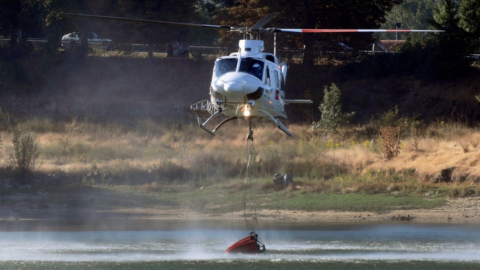Un helicòpter recull aigua per a combatre l’incendi forestal declarat a San Ildefonso - La Granja