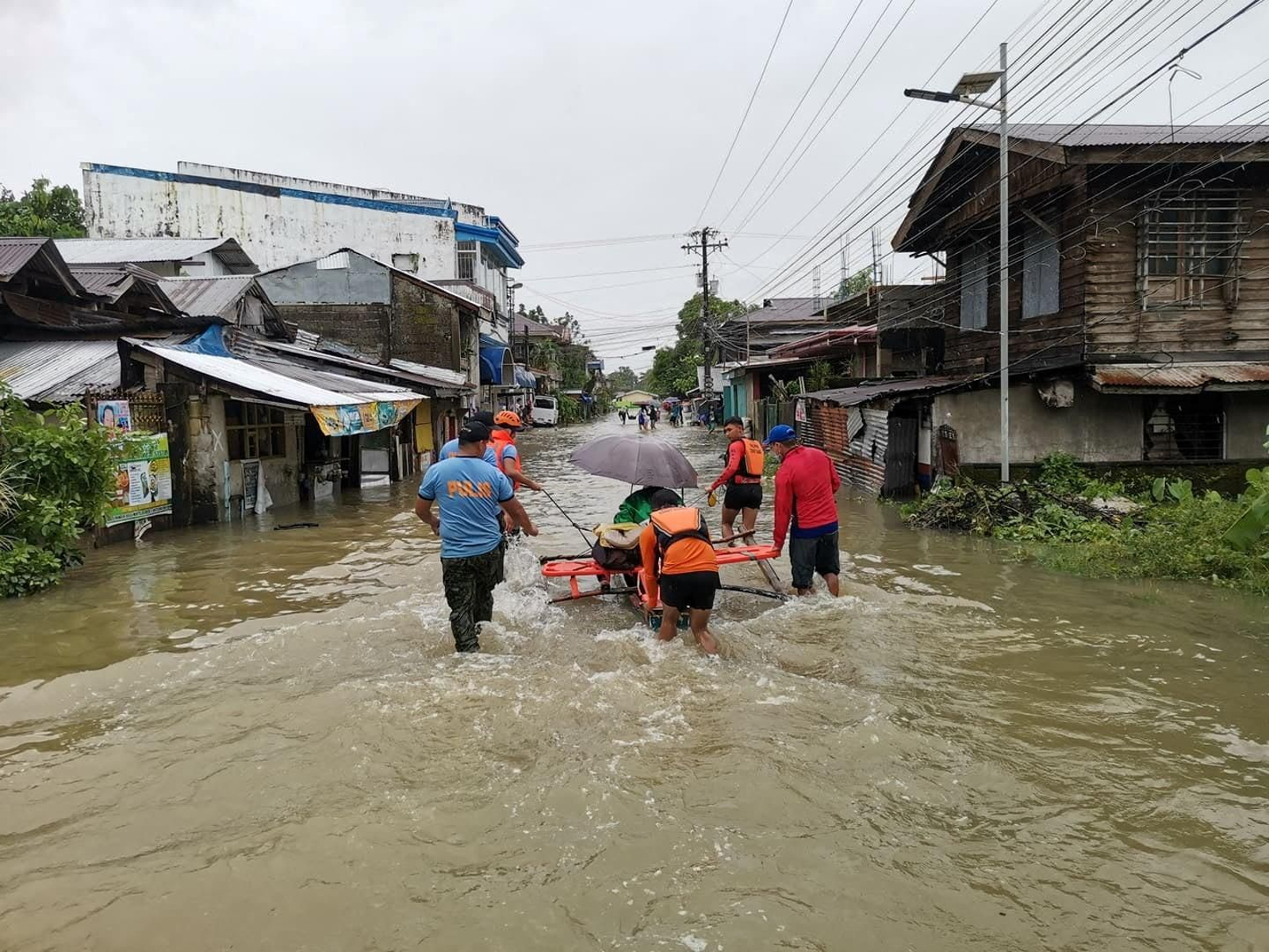 Un equip de rescat espenta una dona a través d'una carretera inundada, a la província de Leyte