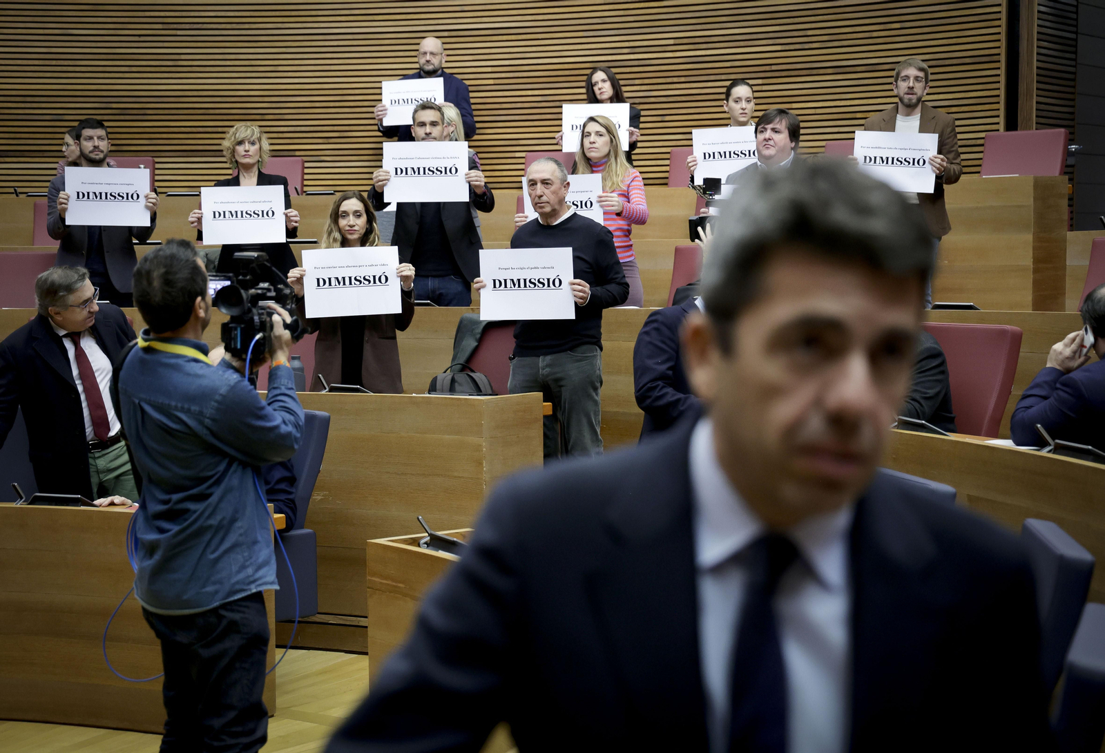 Els diputats de Compromís mostren cartells amb la paraula "dimissió" a l'arribada de Mazón