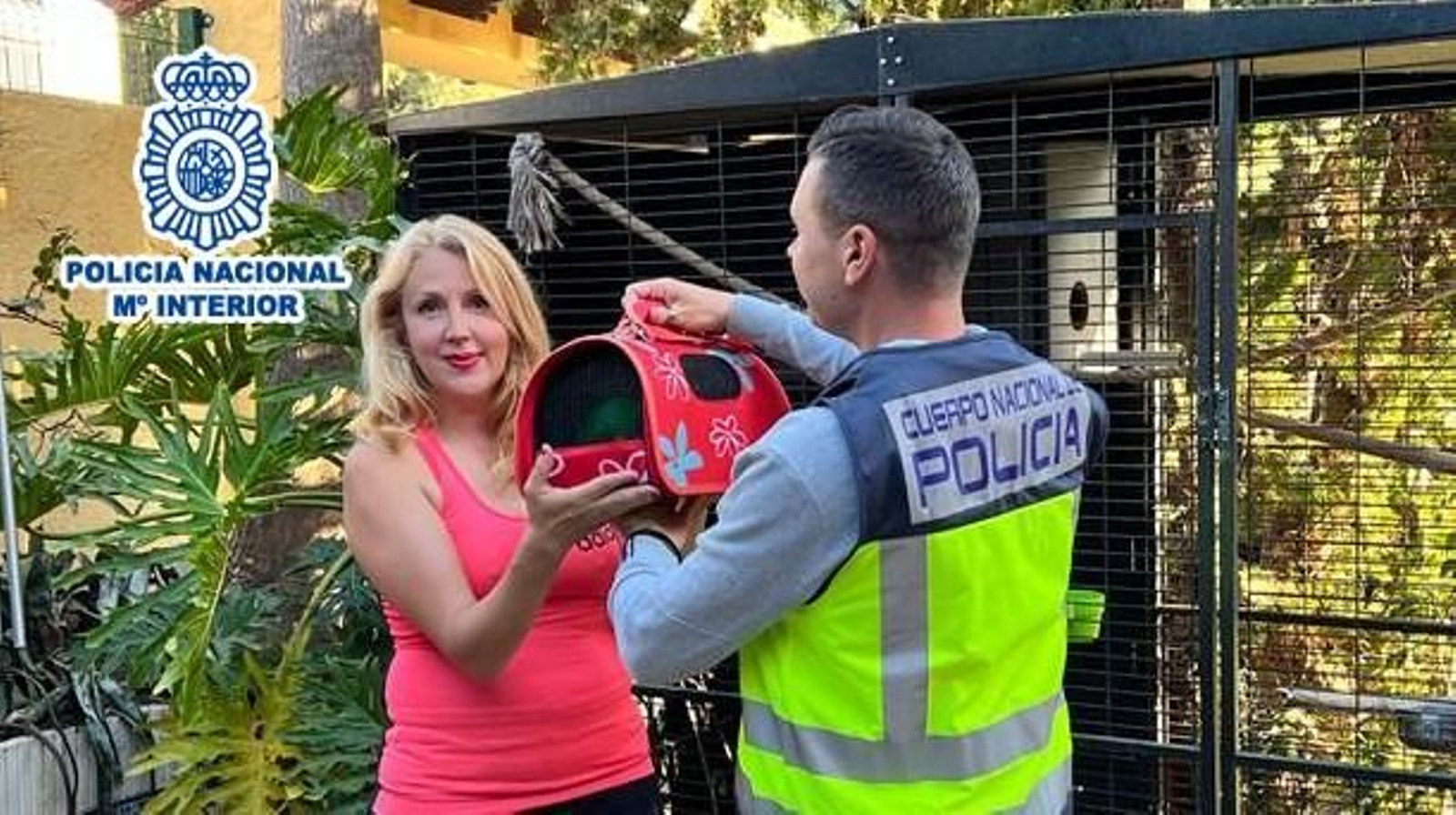 Un agent de la Policia Nacional entrega l'animal en una cistella de transport a la propietària